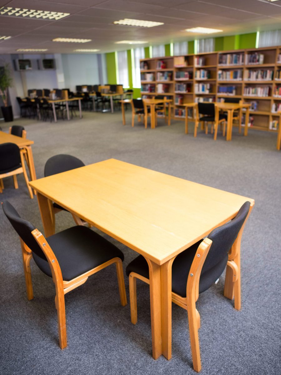 Empty seats with bookshelves in the background at college library