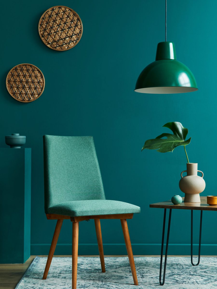 Stylish concept of living room interior with small walnut table, design chairs, tropical leaf in beige vase, clock, retro carpet, decoration and elegant personal accessories in modern vintage home decor.